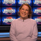 Amy Scnheider smiles while wearing a pink sweater in tribute to her favorite Jeopardy! champion, champion Julia Collins.